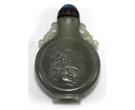 A Chinese jade snuff bottle carved with a dragonfly, lotus and clouds, twin pierced handle and a lapis lazuli cabochon stoppe