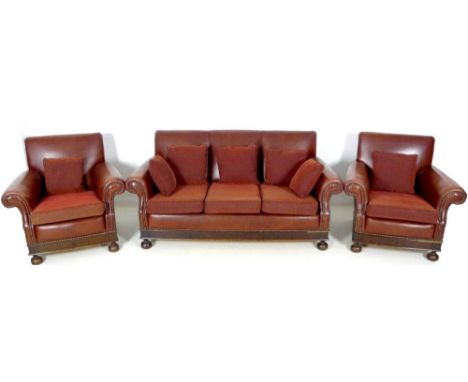 A brown leather three piece suite, mid 20th century, comprising a three seater sofa, 180 by 83 by 90cm high, and two matching