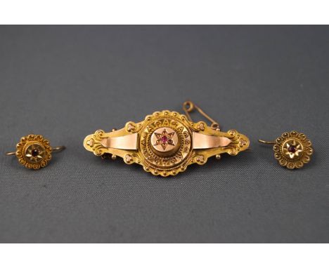 A yellow gold bar brooch of abstract filigree design set with single ruby (all others missing) having a pin and hook fitting 