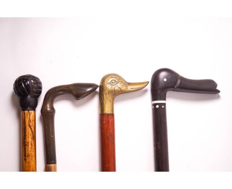 A Country walking stick with carved horn hoof handle, a brass duck's head walking stick, a carved hardwood duck's head walkin