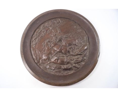 A large bronze charger depicting five horses fighting, signed H W M Caithy(?), 46cm diameter