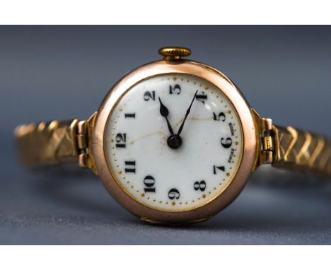 A yellow gold ladies wristwatch. Unbranded. White ceramic numerical dial. Blued hands. Manual wind Swiss movement - 15 Jewels
