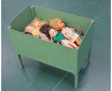 A collection of vintage dolls in green-painted cot