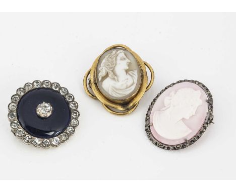 A Victorian enamel and paste white metal target brooch, together with two shell carved cameo brooches