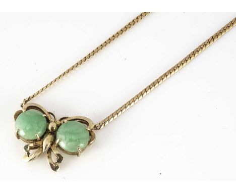 A 14ct gold and jadeite jade butterfly pendant and chain, the two circular cabochons claw set and applied to the wings of the