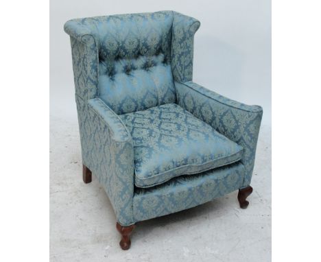 A button upholstered wingback armchair raised on cabriole front legs.