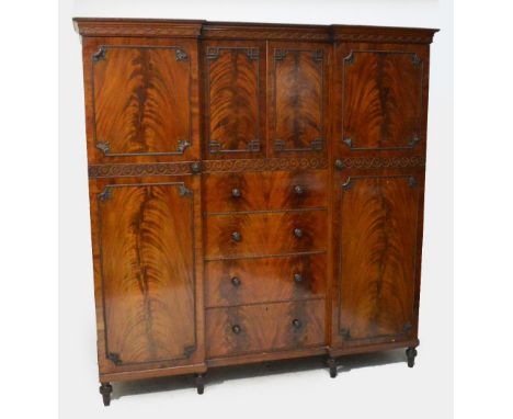 The en-suite wardrobe; an Edwardian mahogany bead decorated invert breakfront wardrobe, the moulded cornice above fretwork de