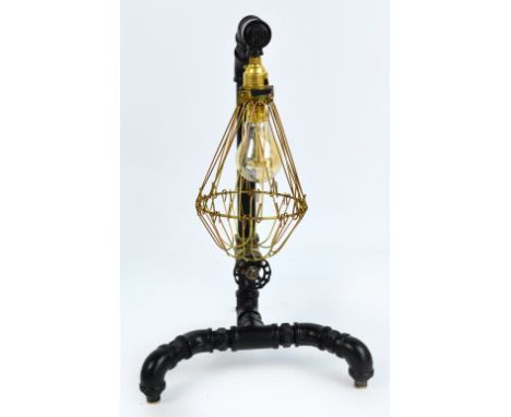 An unusual "Steampunk" black painted and brass lamp with single wire cage shade, height 51cm.