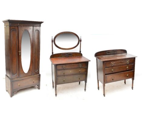 A 1920s oak three piece bedroom suite comprising mirrored wardrobe with drawer to base, three drawer chest and three drawer d