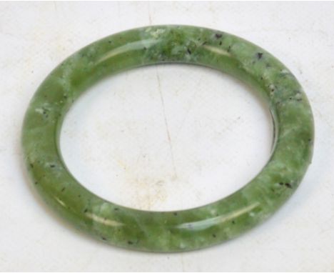 A 20th century Chinese green hardstone bangle, interior diameter 6cm.