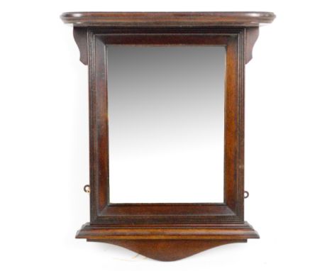 An Edwardian mahogany mirrored wall shelf with arched pediment above rectangular bevelled plate, height 47cm.