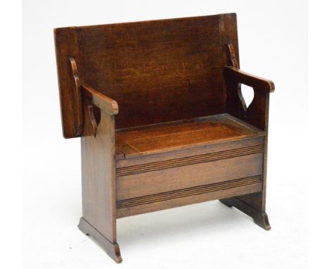 An early 20th century oak monk's bench raised on plank end supports, width 90.5cm.