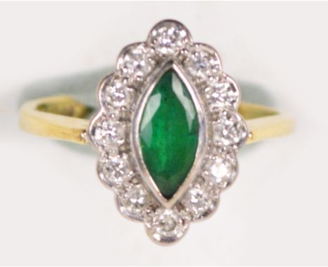 An 18ct yellow gold dress ring, the marquis cut emeralds surrounded by twelve small brilliant cut diamonds, size I/J.