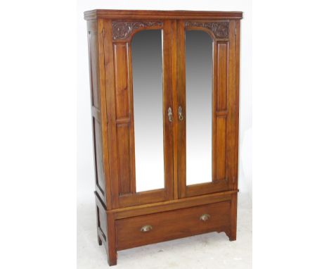 A late Victorian/Edwardian double mirror door wardrobe with carved detail.