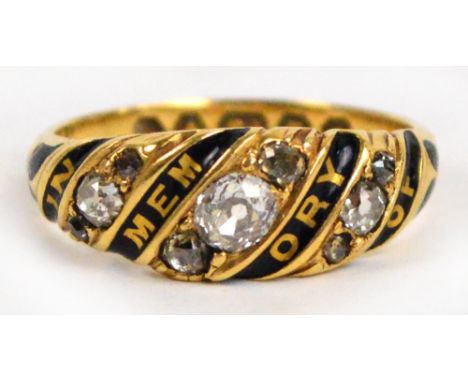 A Victorian 18ct yellow gold mourning ring set with three rows of old mine cut diamonds with alternating black enamel bands i