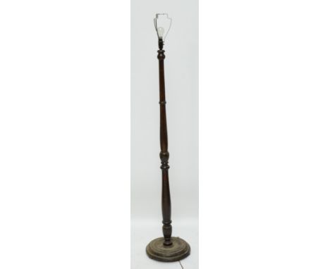 A turned oak standard lamp on circular base.