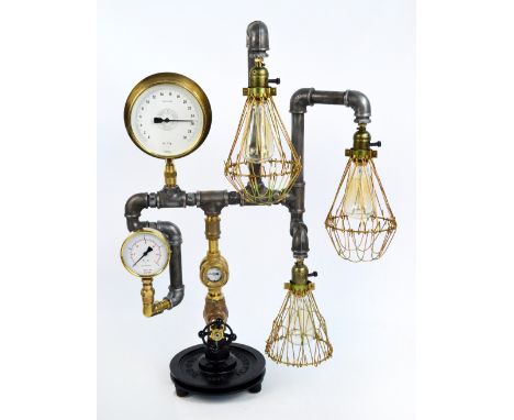 An unusual "Steampunk" three light lamp constructed from brass, and polished tubular metal raised on flywheel cast iron base,