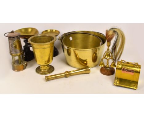 A quantity of brassware including a large pestle and mortar, two jam pans, a money box, scales with weights, a miner's lamp, 