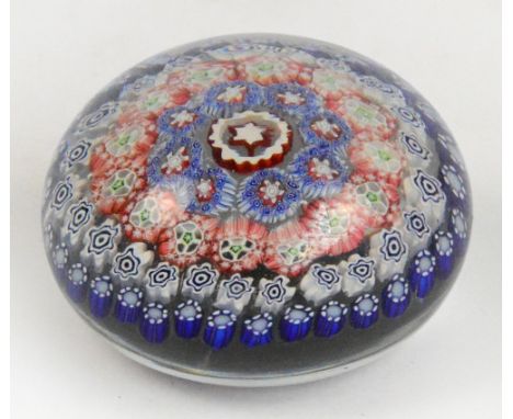 A Clichy glass paperweight with concentric polychrome cane inserts, diameter 7cm. CONDITION REPORT: There are two opposing 15