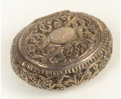 An early 20th century Indian white metal oval snuff box embossed throughout with foliate scrolls, width 7.5cm. CONDITION REPO