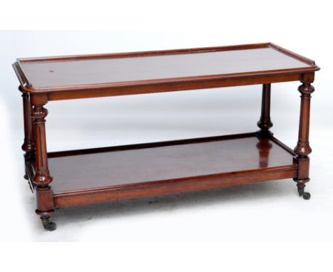 A Victorian mahogany two tier buffet with rounded rectangular top above fluted turned uprights, single shelf and squat turned