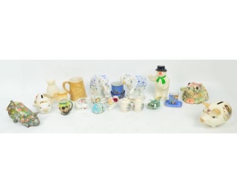 A mixed lot of ceramics to include a collection of money banks, a pair of blue white and gilt performing elephants, a Noritak