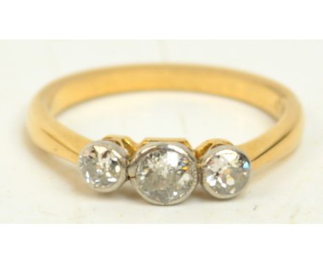 An 18ct yellow gold three stone collet set diamond ring, the central stone of approx 0.25cts, flanked by two slightly smaller