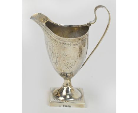 A George III hallmarked silver helmet cream jug with bright cut decoration, raised on spreading circular foot to square base,