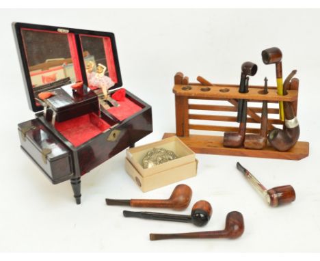 An oak pipe rack modelled as a five-bar gate, nine various pipes, a lacquered musical trinket box in the form of a piano, sun