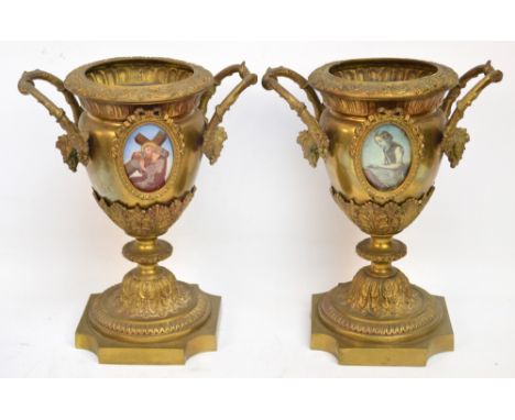 A pair of late 19th century gilt metal urns, the interwoven branch form handles set with leaf adornments above an acanthus ca