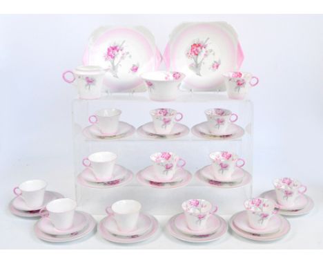 A Shelley pink and white floral decorated tea service, W12416, comprising two bread and butter plates, thirteen cups, twelve 