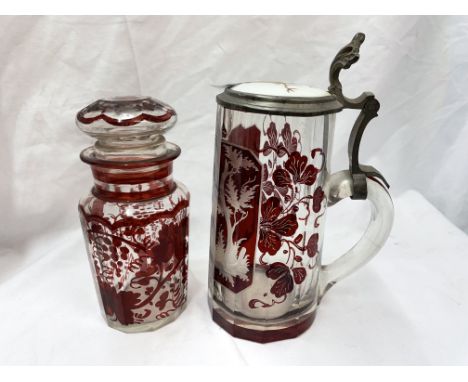 BOHEMIAN RUBY ETCHED STAG IN FOREST PANEL WITH GLASS CERAMIC LIDDED STEIN AND A BOHEMIAN RUBY ETCHED PANELLED JAR AND STOPPER