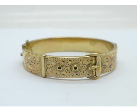 A 1/5th 9ct gold and metal core buckle bangle, dented on the back 