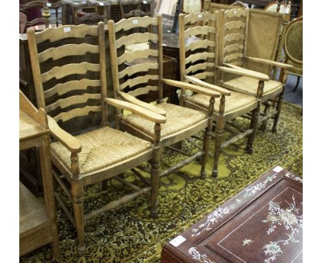 A set of four ladder back chairs with rush seats and open arms