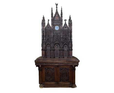 A 19th Century carved Italian cabinet modelled as Siena Cathedral, with clock to the top centre, the blue enamel dial signed 