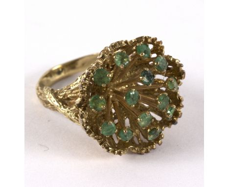 A 14k gold and enamel dress ring of modern design, the fourteen round cut emeralds on stalks with a textured gold surround, a