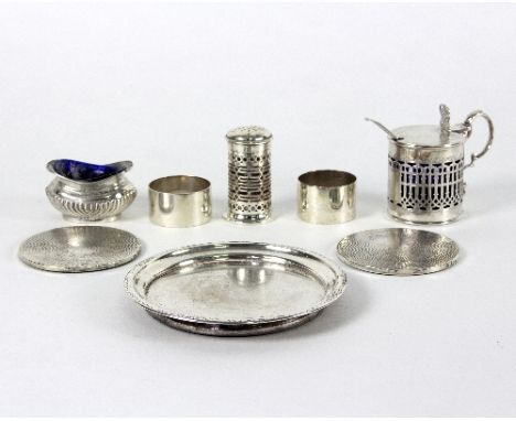 A silver mustard pot, Sheffield 1894, a small silver circular stand, two napkin rings, two coasters, a pepper pot, a salt and