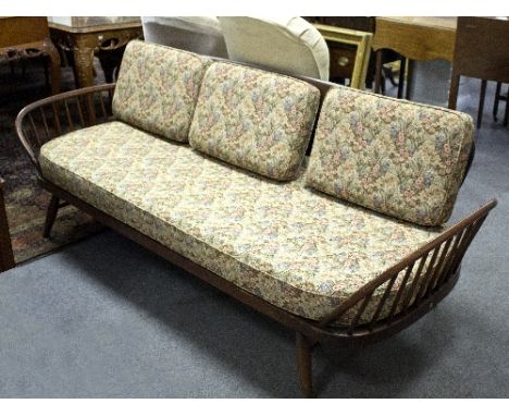 An Ercol settee with panel back and rail supports to the arms, fitted loose cushions, 81.5cm wide