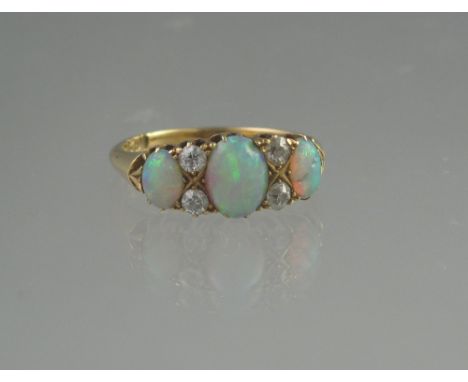 VICTORIAN 18CT GOLD THREE TONE OPAL RING. The three graduated oval opals separated by two pairs of diamonds. Ring size O. Wei