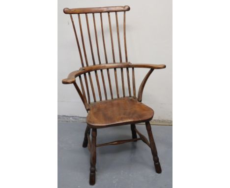 19TH CENTURY PRIMITIVE COMB AND STICK BACKED FIRESIDE ELBOW CHAIR with moulded saddle seat on baluster turned legs with singl