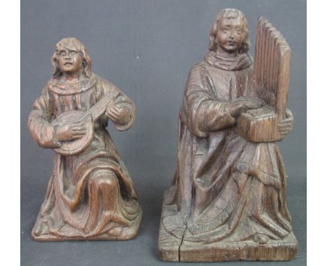 TWO SIMILAR CARVED OAK MUSICIAN FIGURES in Medieval style, both seated one playing lute type instrument, the other playing a 