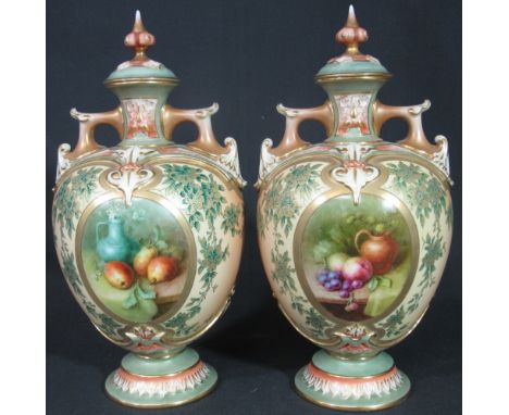 PAIR OF ROYAL WORCESTER BLUSH IVORY TWO HANDLED LIDDED BALUSTER PEDESTAL VASES, the oval central panels painted with fruit an