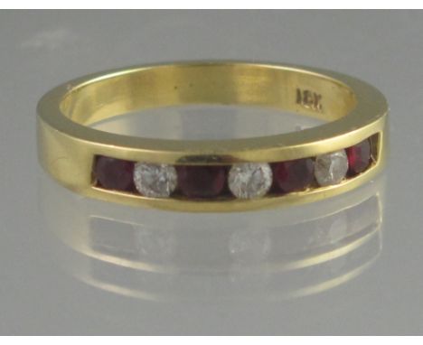 18CT RUBY AND DIAMOND HALF ETERNITY STYLE RING. The four rubies and three brilliant cut diamonds channel set. Ring size N. We