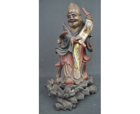 CHINESE CARVED STAINED AND GILDED WOODEN STATUE OF THE DEITY SHOU-LAO, holding a gilded skull with calligraphy and standing o