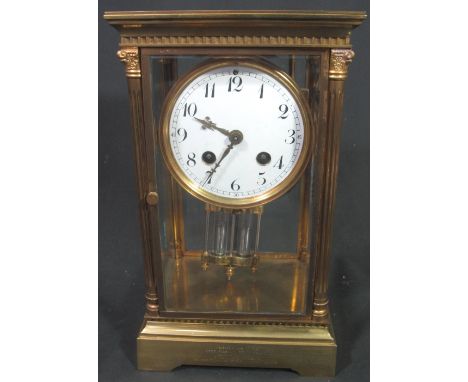 EARLY 20TH CENTURY FRENCH GILT BRASS FOUR GLASS PRESENTATION MANTEL CLOCK having circular Arabic enamel face flanked by Corin