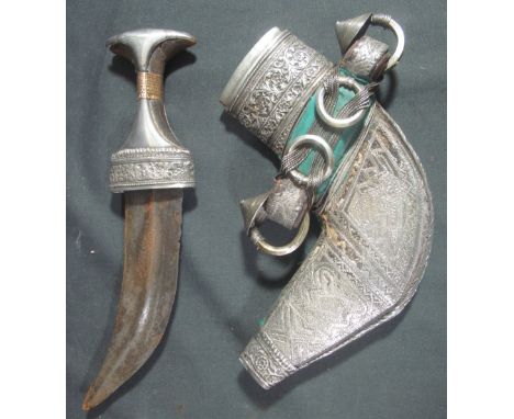 AN OMANI ARAB JABIYA DAGGER, having foliate engraved silver and yellow metal mounted handle, ribbed curved double edged blade