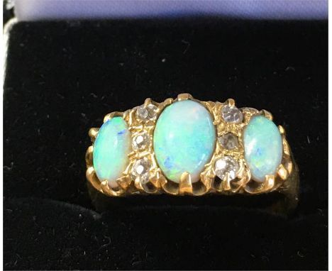 18ct Gold opal and diamond ring with 3 opals and 6 small diamonds set in hallmarked 18ct gold central opal measures approx 8m