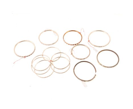 Seven vintage narrow bangles set with clear and coloured paste, five with clear paste, one purple and clear, one red and clea