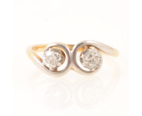 A diamond two stone ring, the old brilliant cut stones claw set in a yellow and white metal mount with the white metal should