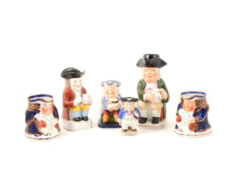 A Staffordshire Toby jug, Mr Toby seated with a jug of ale and pipe, 27cm; a Copeland Spode Toby jug; and four others.